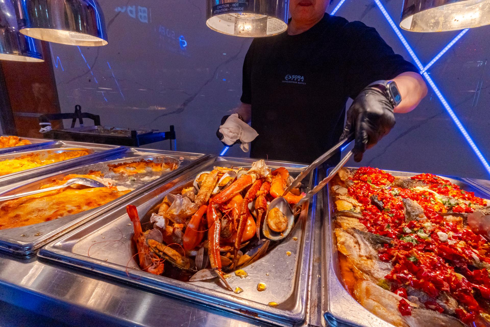Snow crab legs, oysters and shrimp on ice at the seafood station