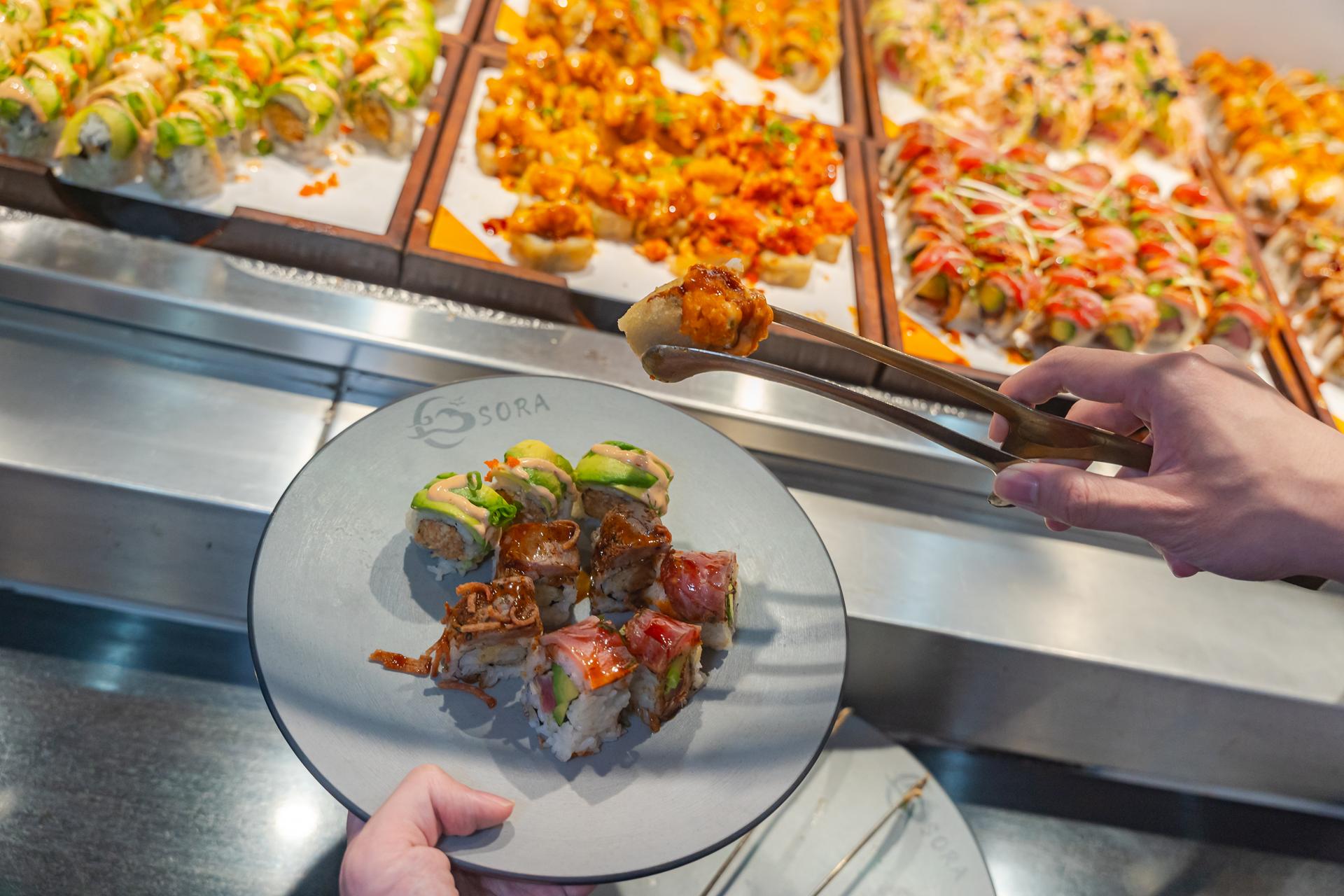 Sushi chef preparing fresh nigiri at the live sushi bar